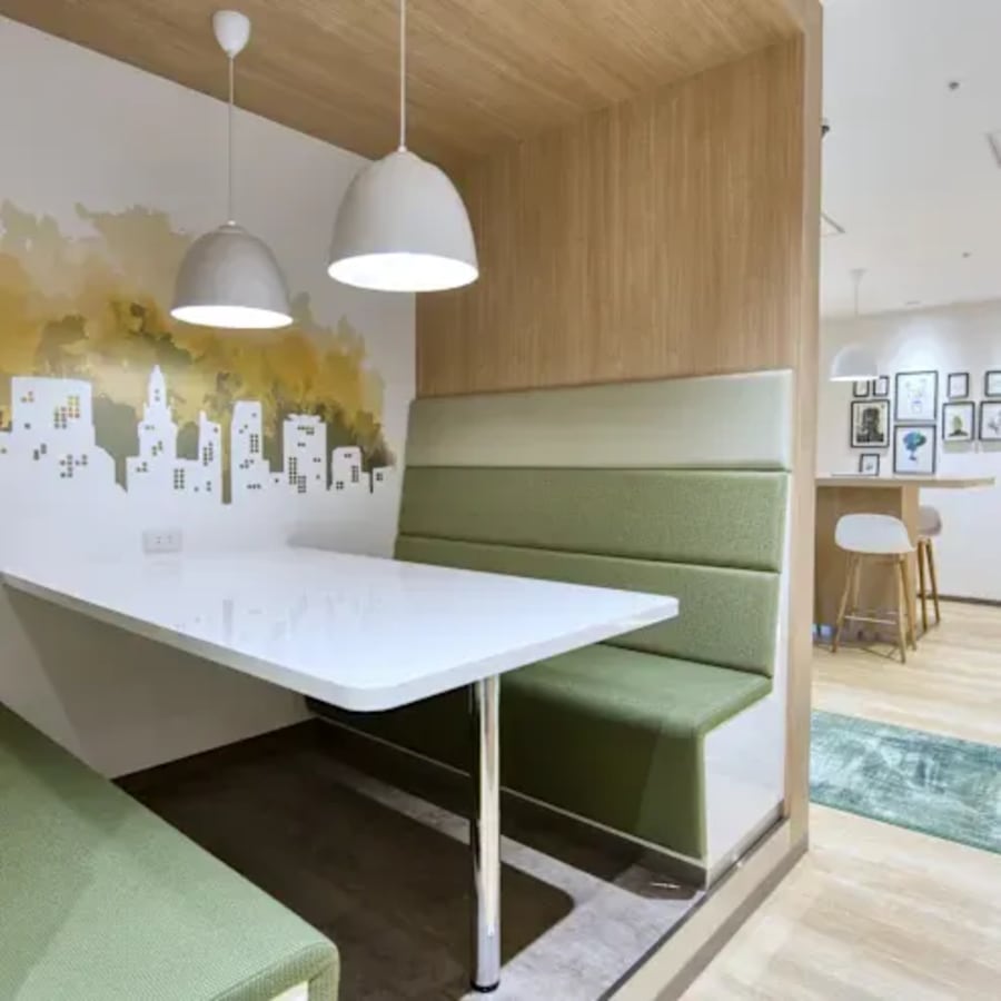 Cozy booth seating with modern lighting and artistic walls in a Taguig coworking space.