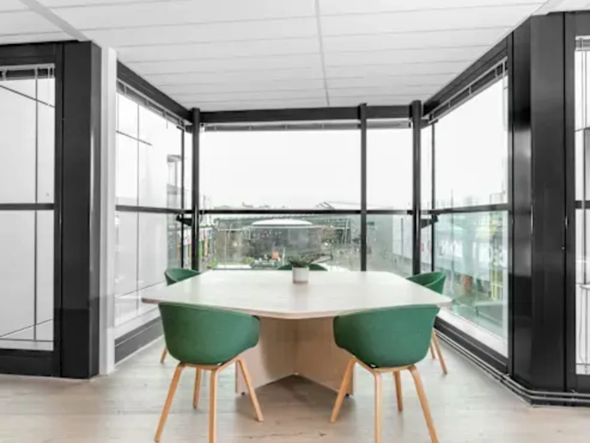 Bright corner workspace with large windows, modern seating, and a sleek table in Metro Manila.