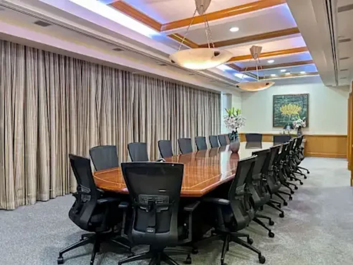 Spacious boardroom with a polished conference table, ergonomic chairs, and elegant lighting.