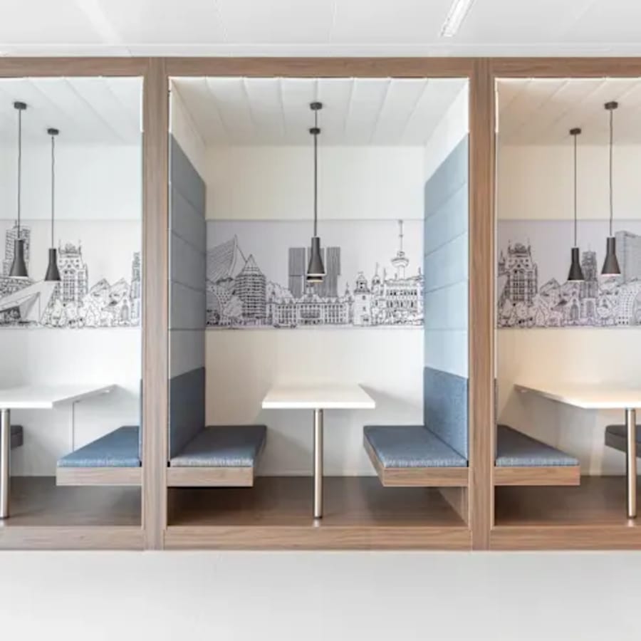 Sleek, private booths with cityscape decor, ideal for focused work in a vibrant coworking space.