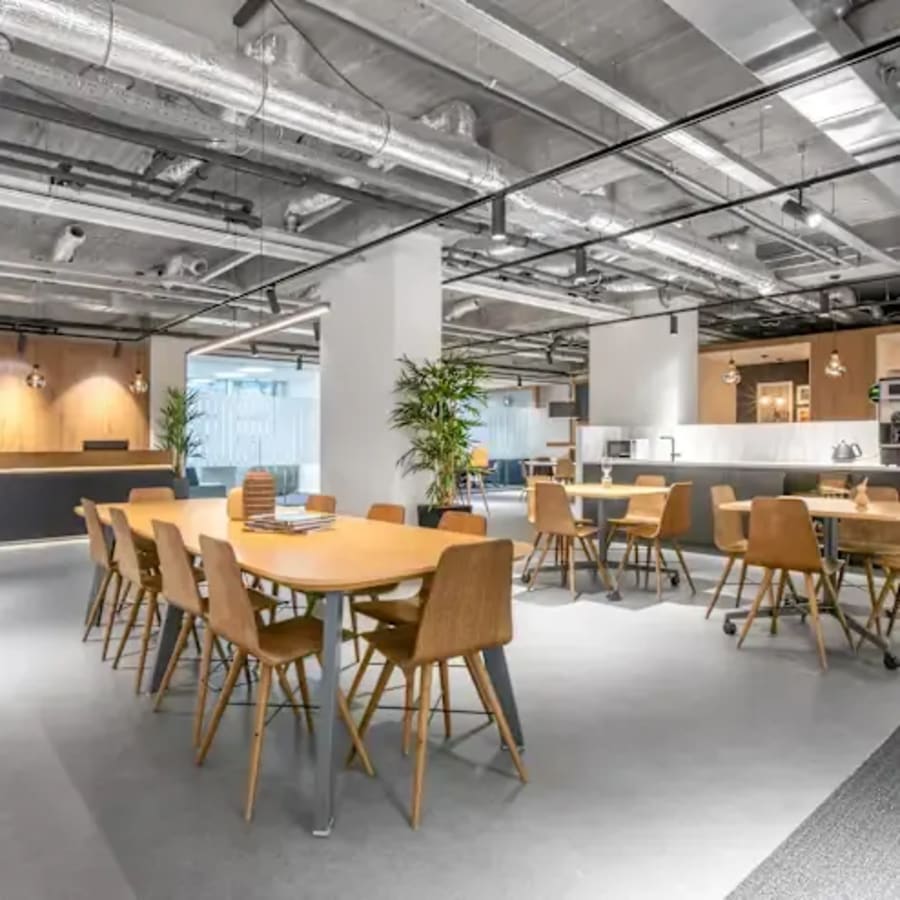 Modern coworking space with open seating, natural light, and kitchen amenities in Metro Manila.