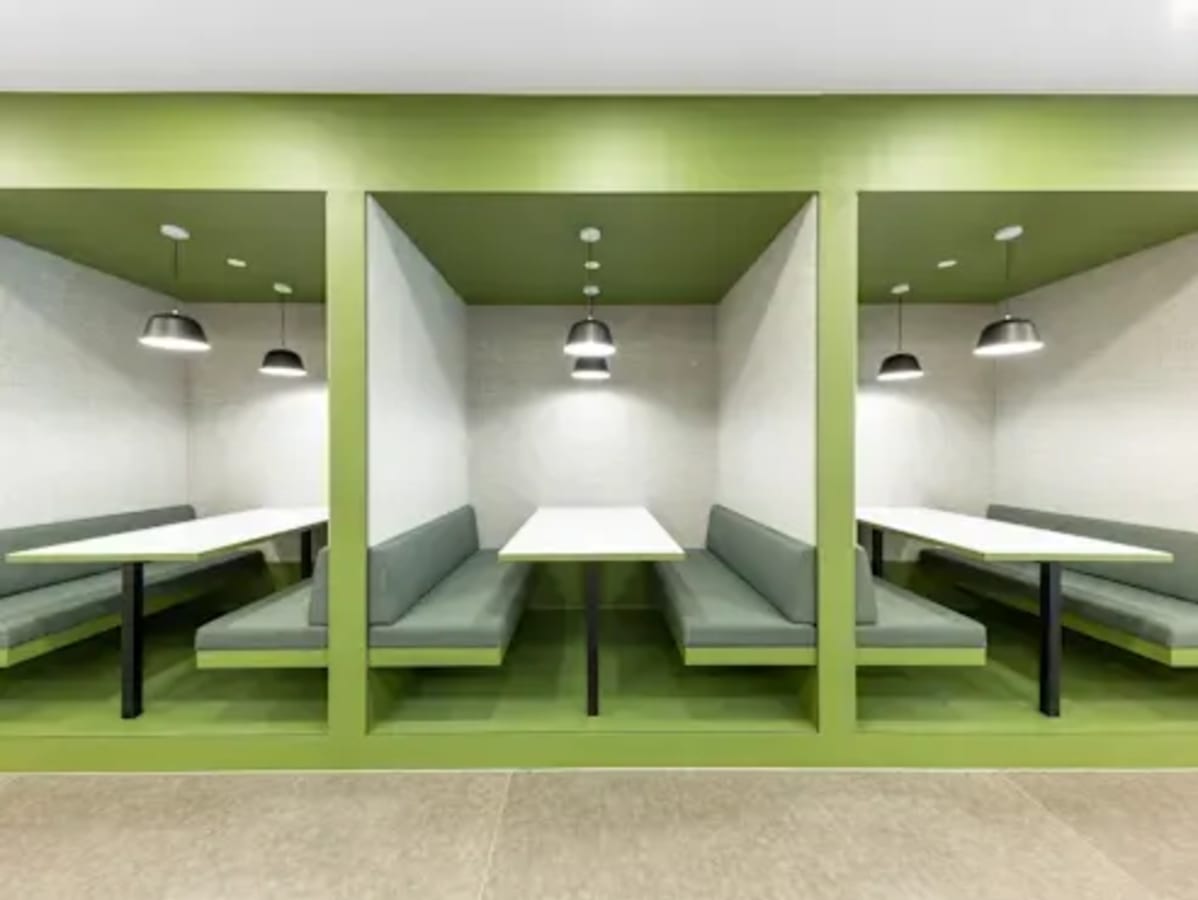 Modern coworking booths with sleek lighting and vibrant green accents in Metro Manila.
