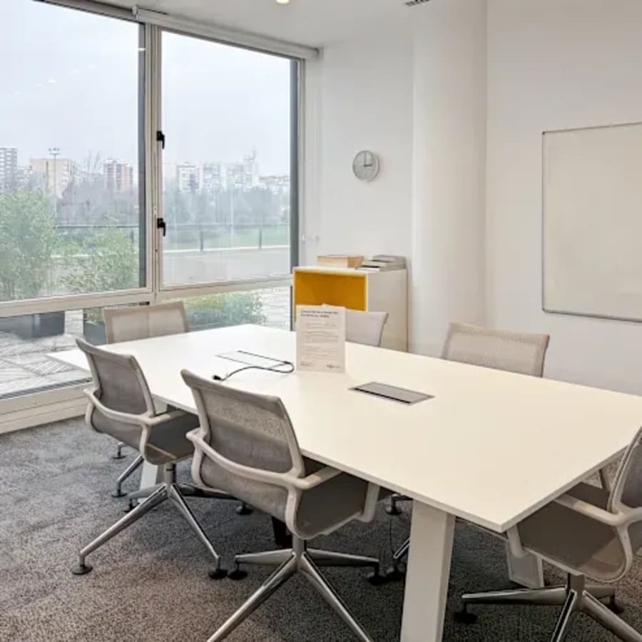 Bright, modern coworking space with natural light, ergonomic chairs, and a city view.