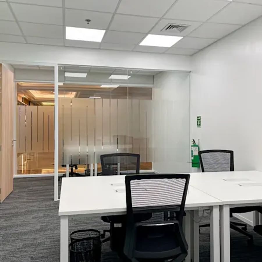 Modern coworking space with sleek desks, ergonomic chairs, and abundant natural light.