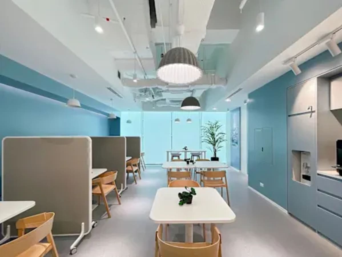 Bright coworking space with modern design, private booths, and ample natural light.
