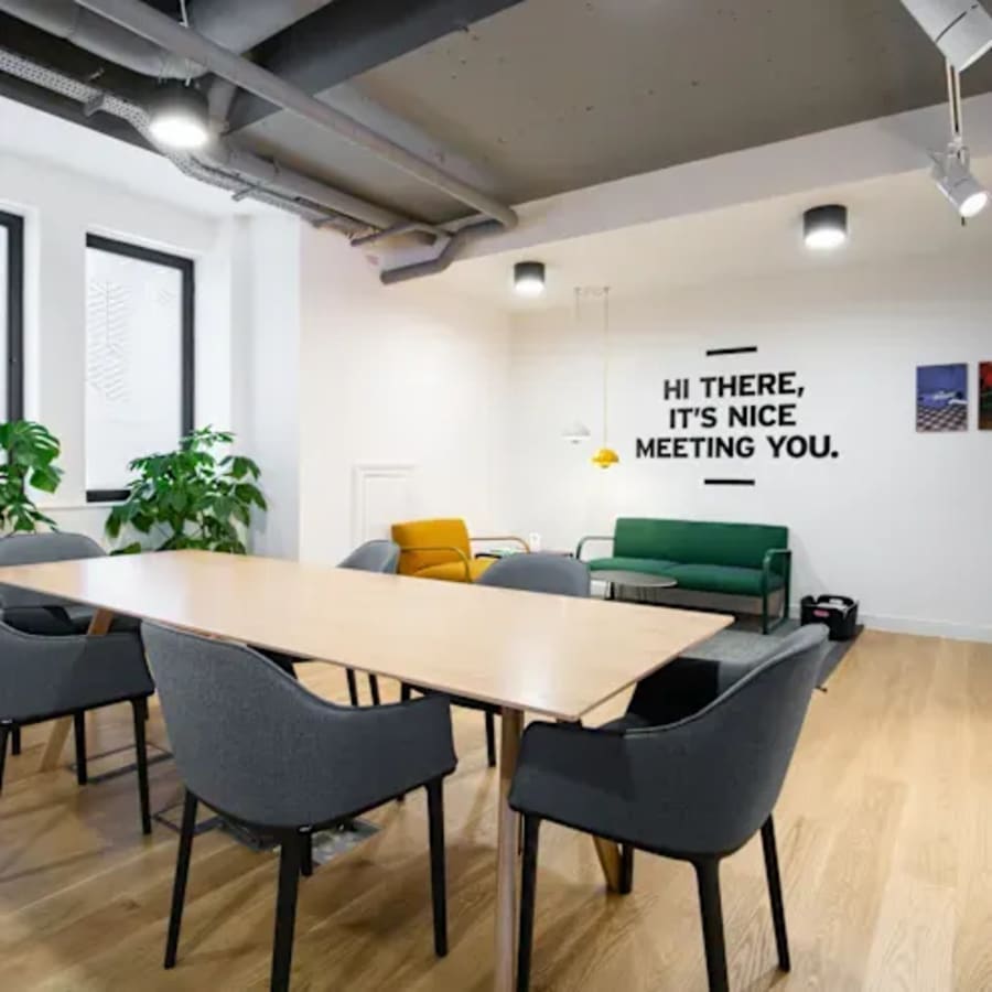 Modern coworking space with stylish seating, bright lighting, and welcoming decor.