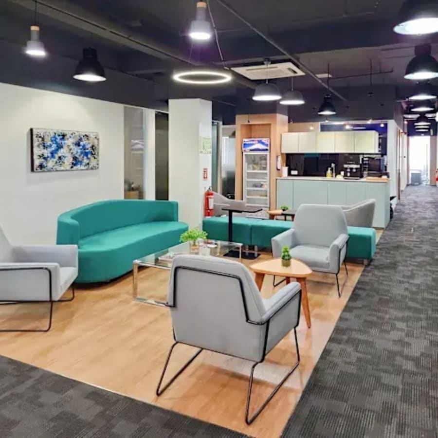 Modern coworking space with cozy seating, vibrant decor, and a well-equipped kitchenette.
