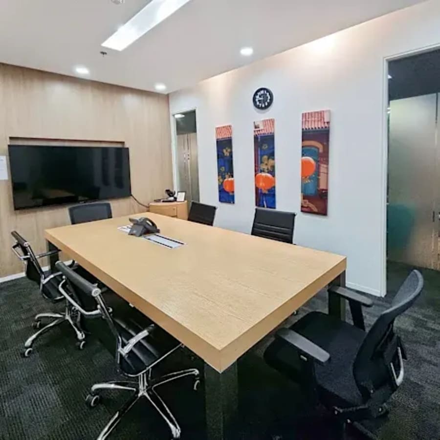 Modern meeting room with sleek furnishings, digital display, and bright decor. Ideal for collaboration.