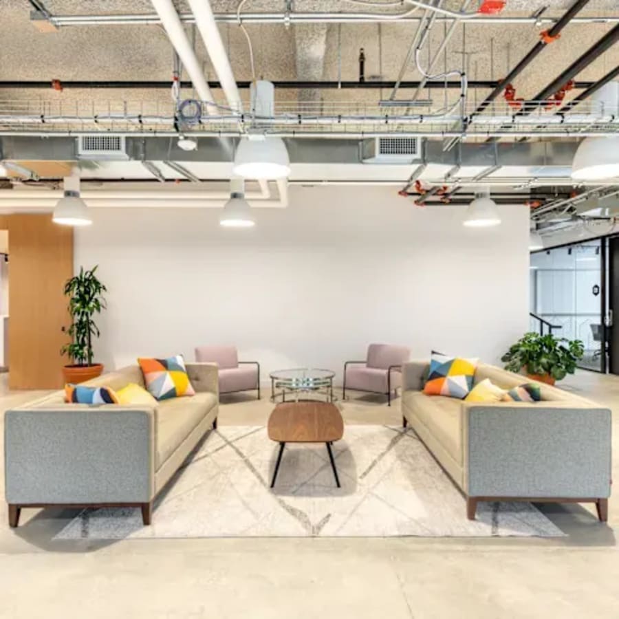 Modern coworking space with cozy seating, bright accents, and ample natural light.