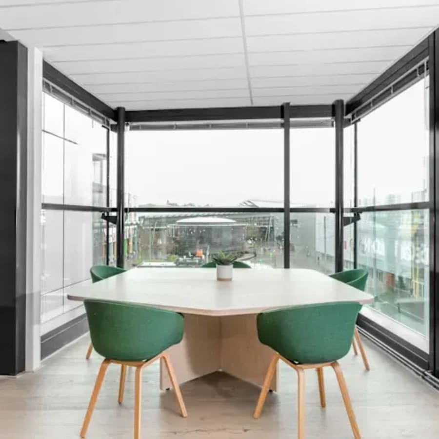 Bright coworking nook with modern seating, natural light, and city views. Ideal for collaboration.