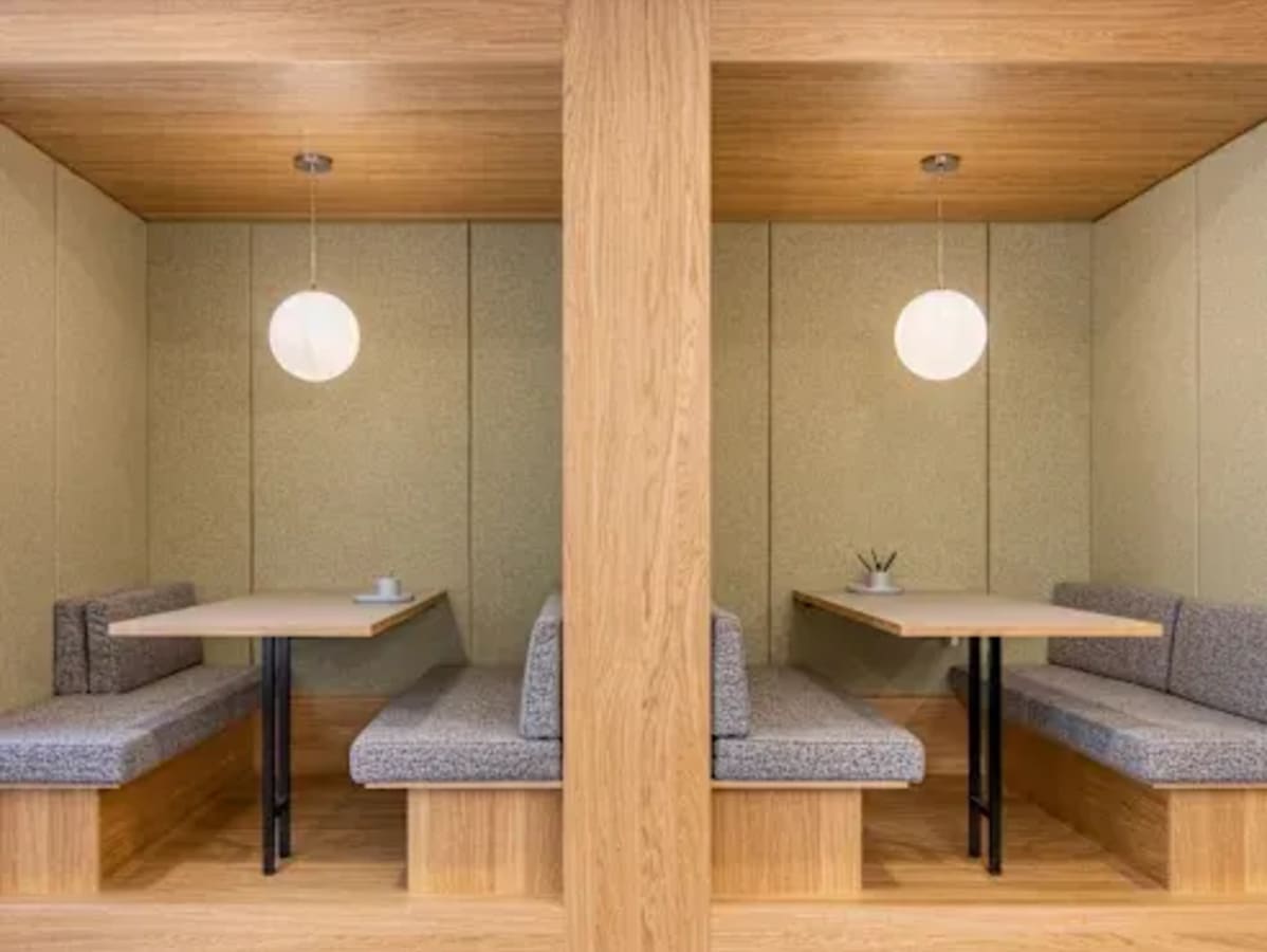 Cozy coworking booths with elegant lighting and comfortable seating for productive meetings.