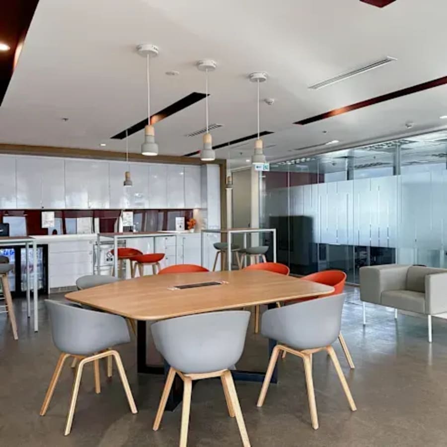 Modern coworking space with stylish seating, natural light, and a sleek kitchen area on Ayala Avenue.