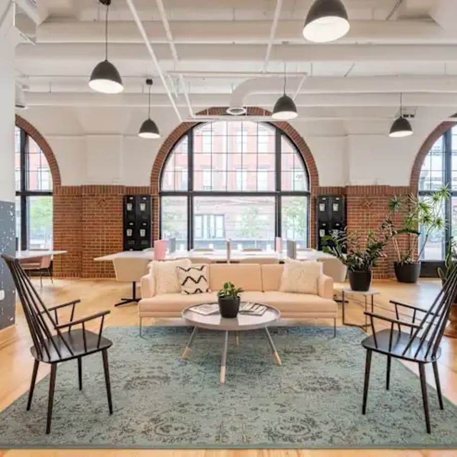 Modern coworking space with natural light, stylish seating, and bright, open layout.