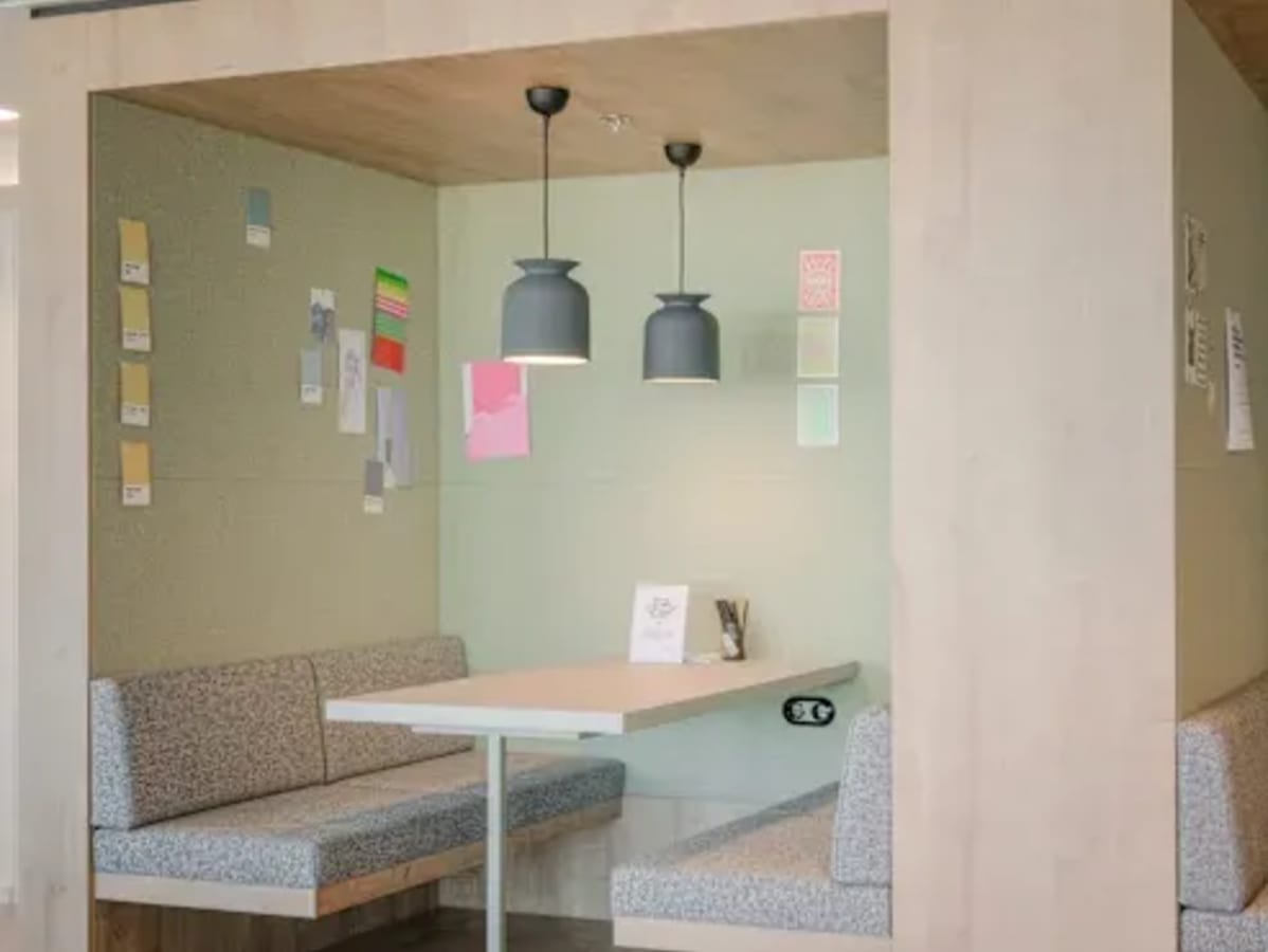 Cozy booth seating with modern lighting, perfect for collaborative work in a flexible coworking space.