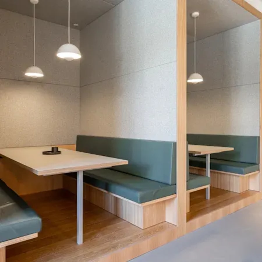 Modern coworking space with cozy booths, sleek lighting, and versatile seating in Raipur.