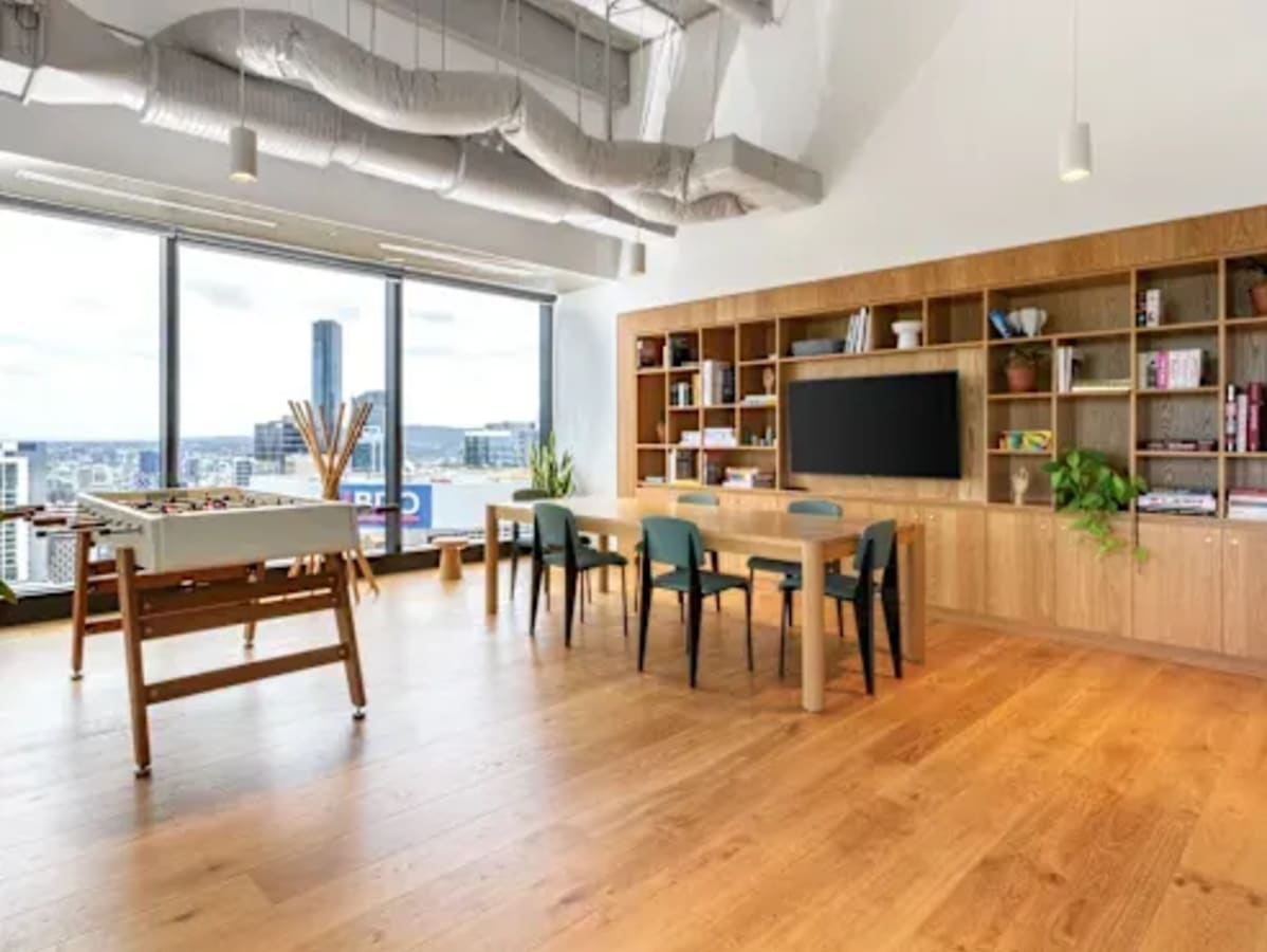 Modern coworking space with panoramic views, ample seating, and built-in bookshelves.