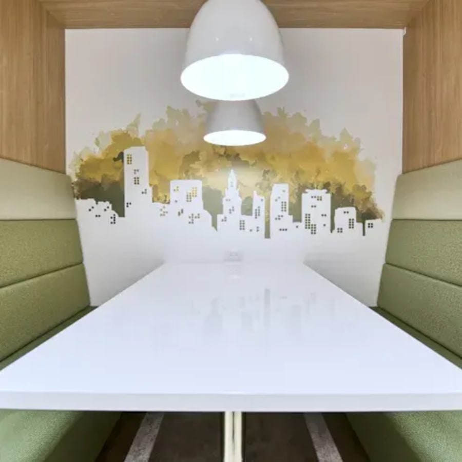 Modern coworking booth with cozy seating and urban mural, perfect for focused work in Hyderabad.