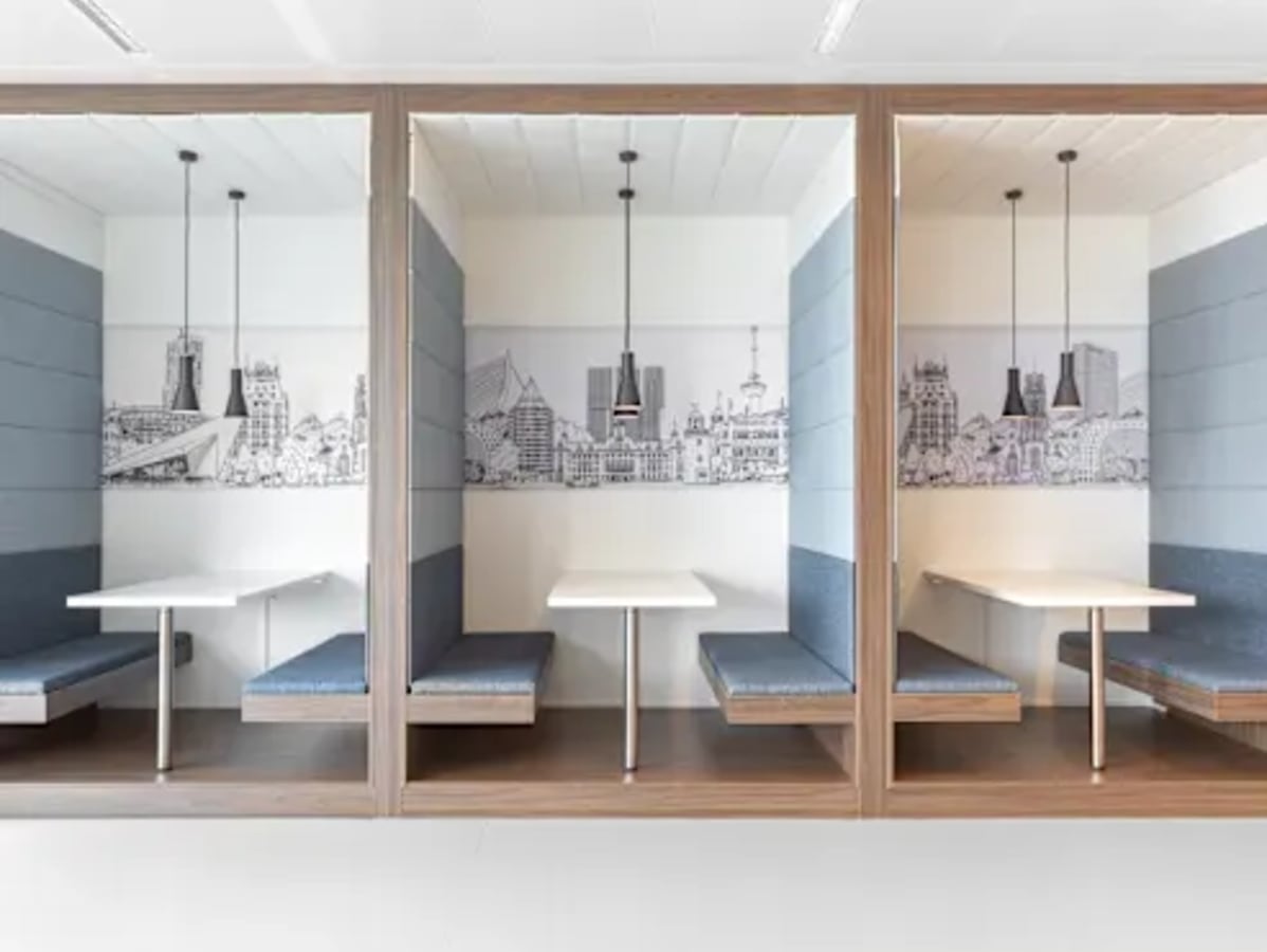 Modern coworking booths with stylish cityscape accents and pendant lighting in Infopark, Kerala.