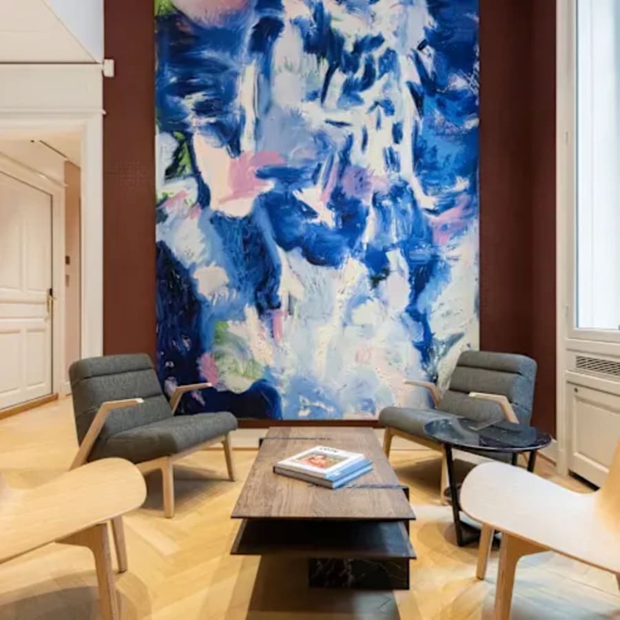 Cozy lounge area with stylish chairs, vibrant artwork, and natural light, ideal for collaboration.