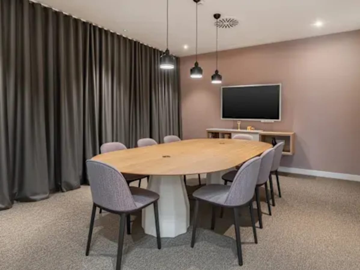 Sleek meeting room with a modern table, plush seating, and ambient lighting perfect for collaboration.