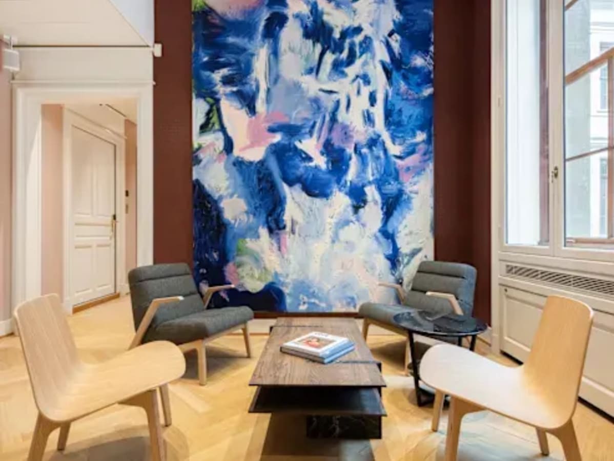 Stylish coworking area with modern chairs, large abstract artwork, and abundant natural light.