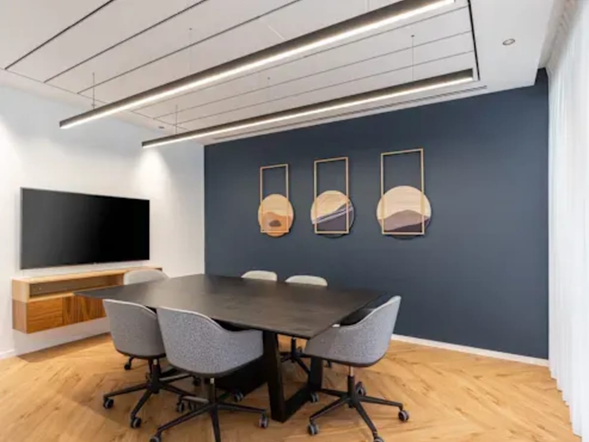 Modern meeting room with sleek furniture, stylish wall art, and natural lighting. Perfect for collaborations.