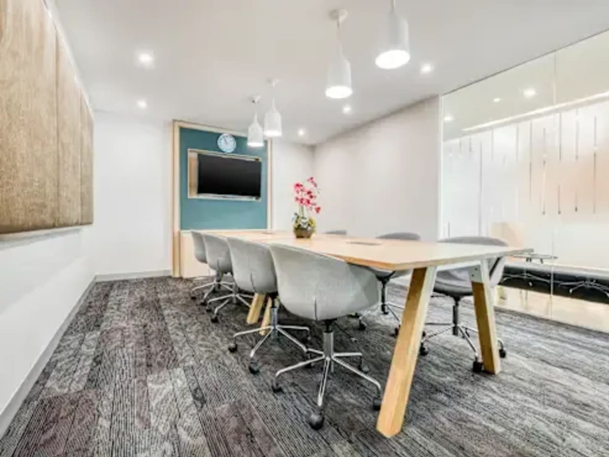 Modern coworking space with sleek design, ample lighting, and a collaborative meeting area.