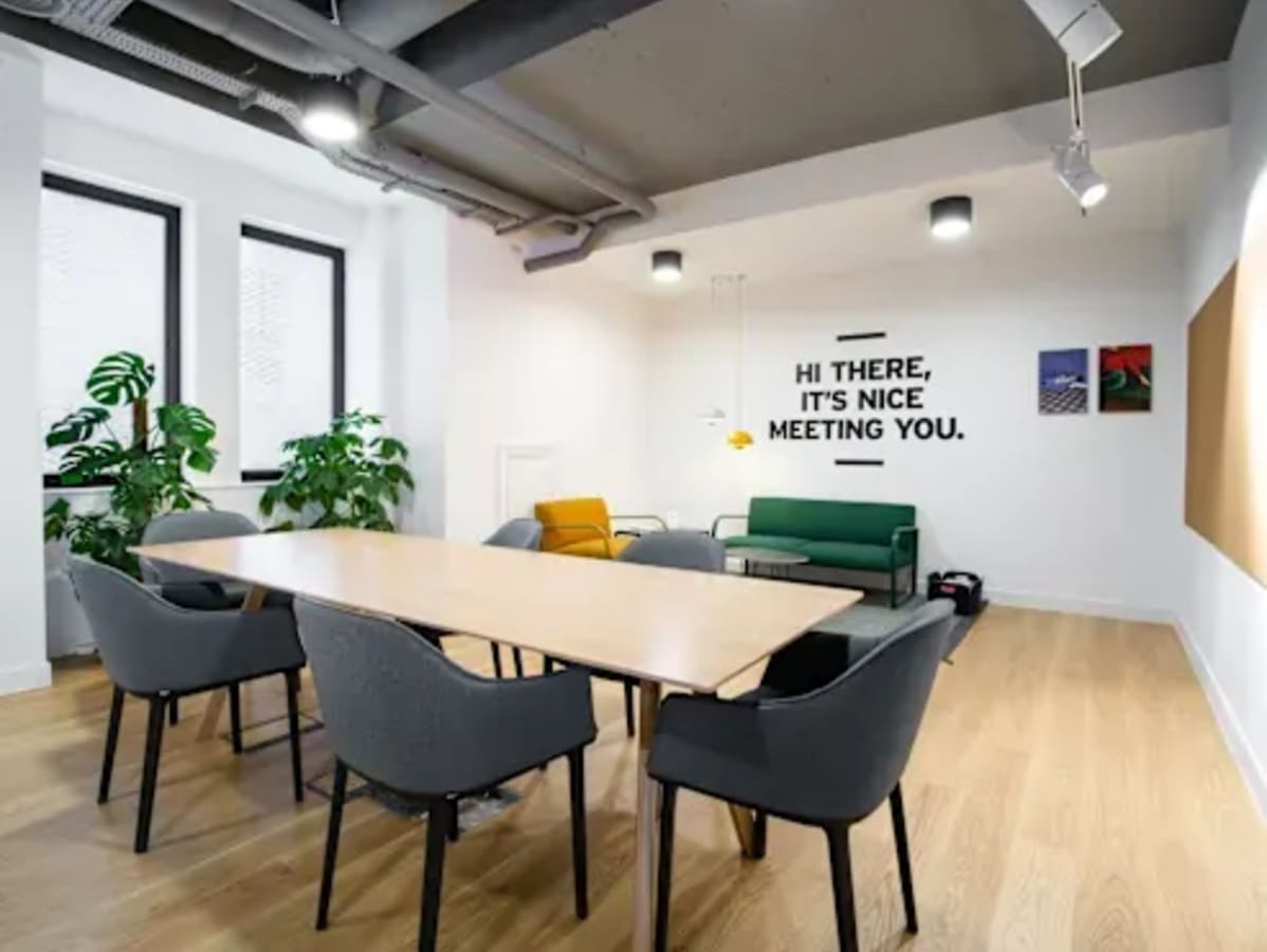 Modern coworking area featuring a spacious table, comfortable seating, and natural light.