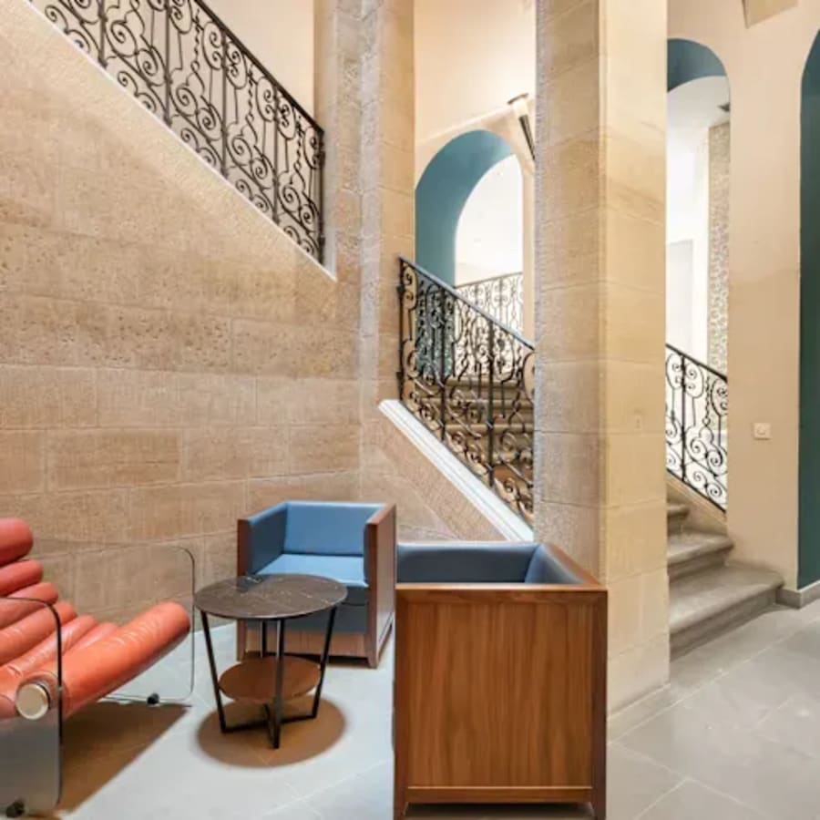 Stylish coworking space with modern seating and elegant stairway, ideal for collaboration.