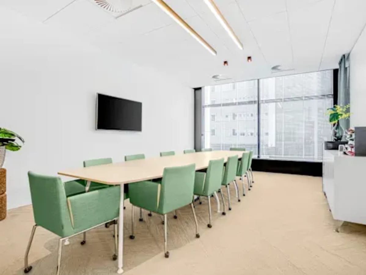 Modern conference room with natural light, sleek furnishings, and ample seating for collaboration.