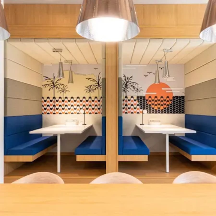 Vibrant meeting booths with seaside-themed murals in a flexible office space on Dr. Annie Besant Road.