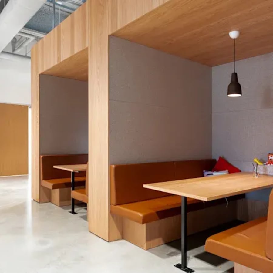 Modern coworking booths with cozy seating and warm lighting on Doctor Annie Besant Road.
