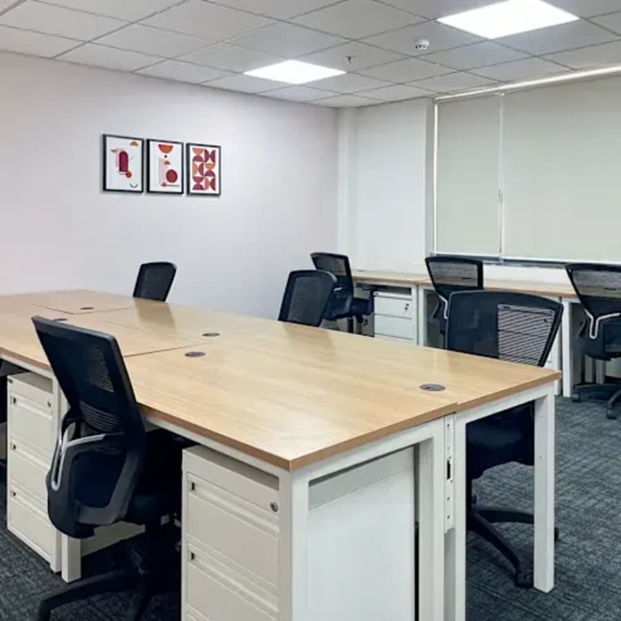 Modern coworking space with ample natural light, ergonomic chairs, and collaborative desks.