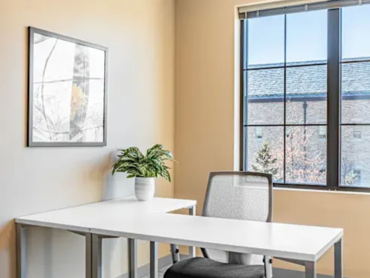 Bright, minimalist workspace with natural light and modern furniture in Ambli - Bopal Road.