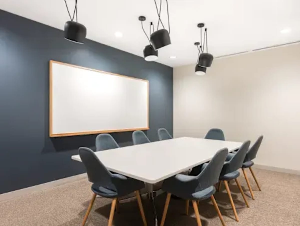 Modern conference room with sleek seating and contemporary lighting, ideal for collaborative work.