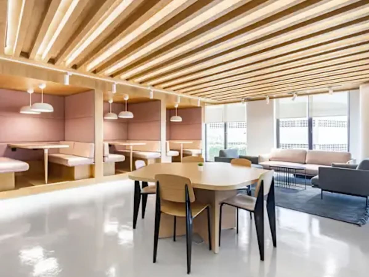 Sleek coworking space on Arcot Road featuring modern booths, ample seating, and bright lighting.