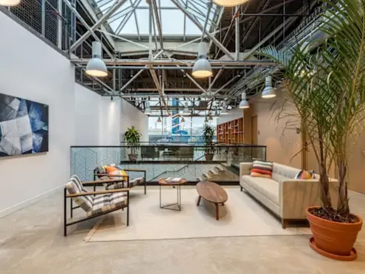 Modern coworking space with natural light, cozy seating, and vibrant plant decor in Kondapur.