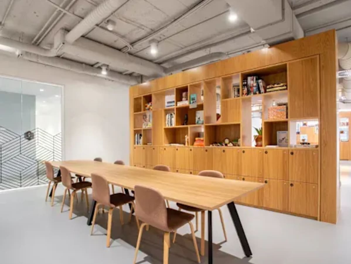 Contemporary coworking area with sleek wood accents and ample seating. Ideal for collaboration.