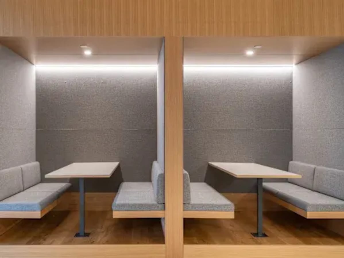 Modern coworking booths with sleek seating and soft lighting, perfect for focused work.