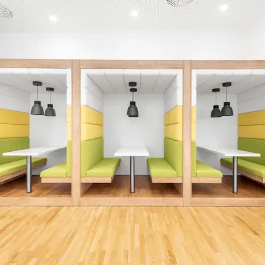 Modern coworking booths with vibrant seating and individual lighting on Neco Garden Road.