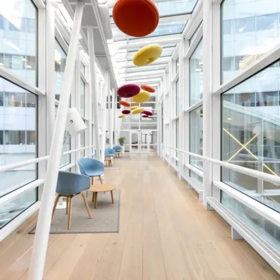 Bright, modern corridor with seating and vibrant decor in flexible coworking space.