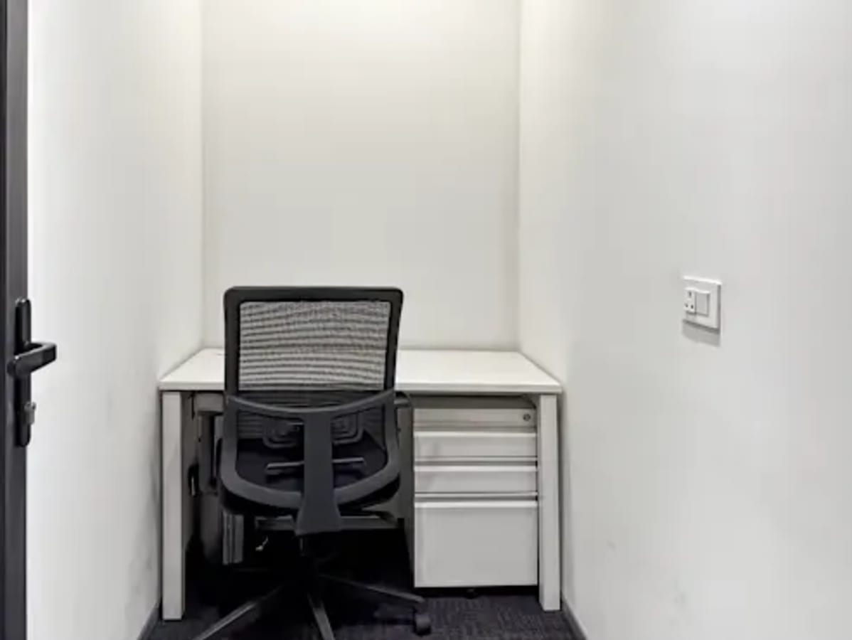 Compact private workspace with ergonomic chair and desk. Ideal for focused productivity.