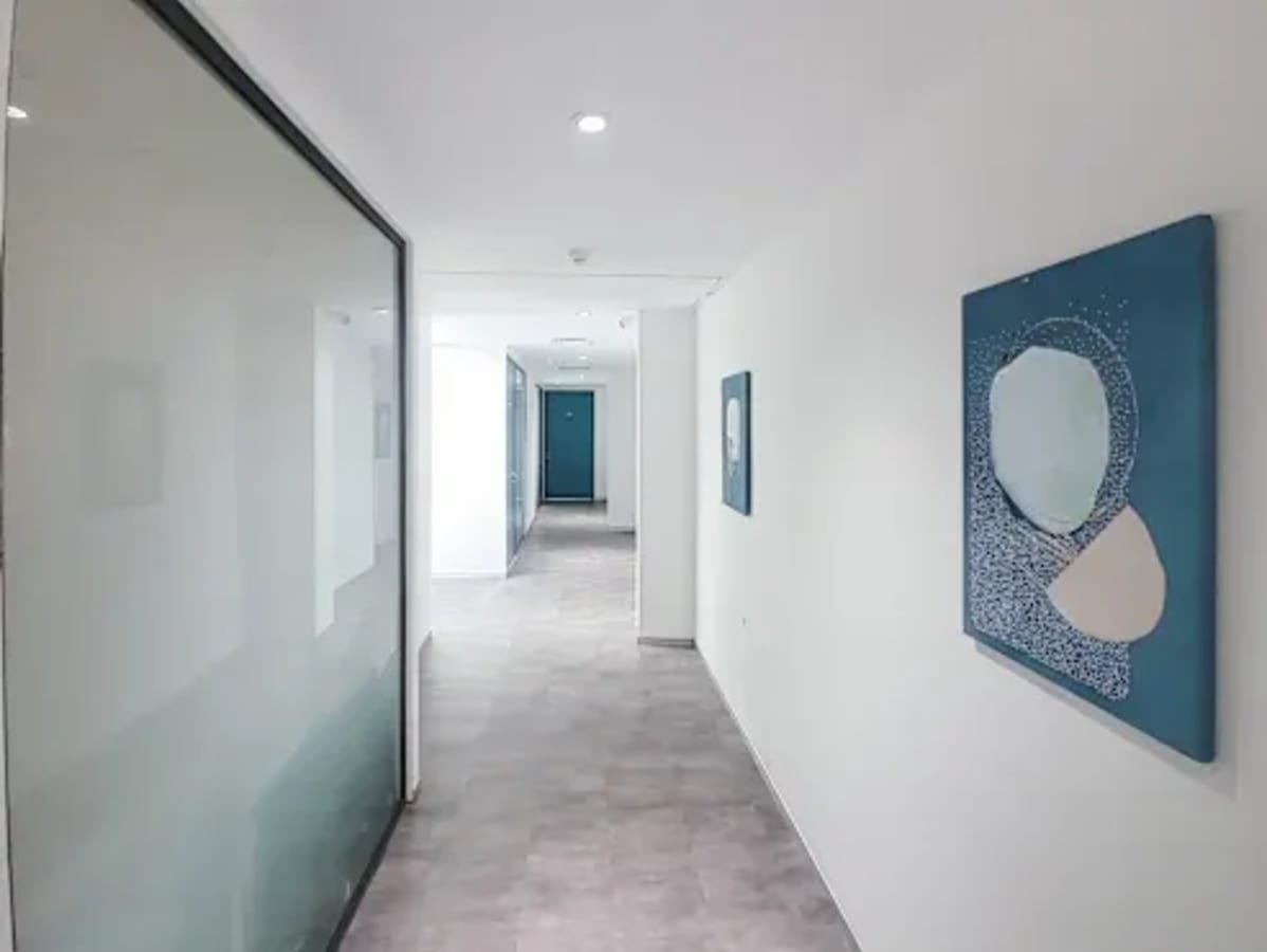 Modern coworking space corridor with minimalist decor and artwork in Chandigarh.
