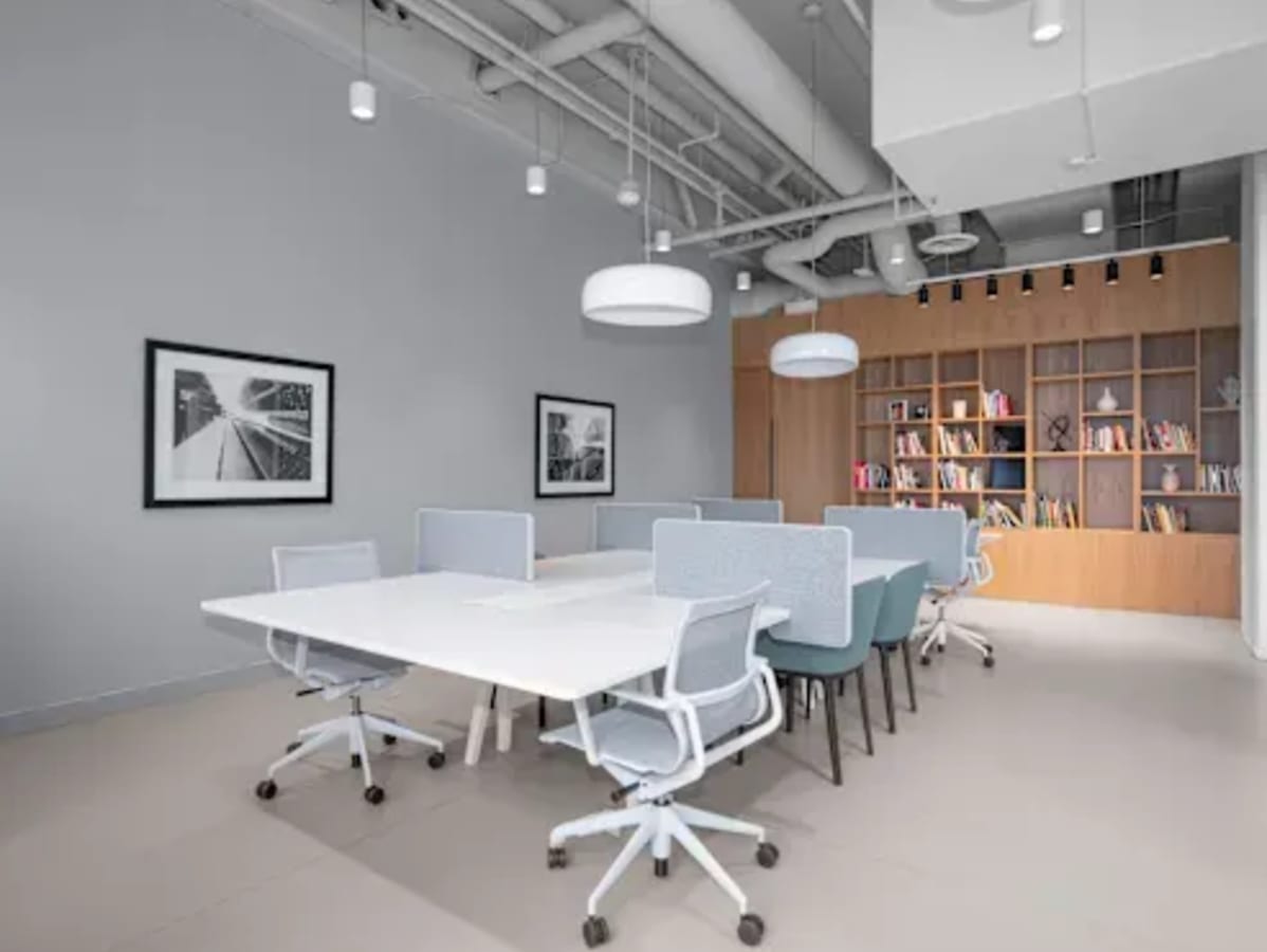 Modern coworking space with sleek meeting tables, ergonomic chairs, and ample natural light.