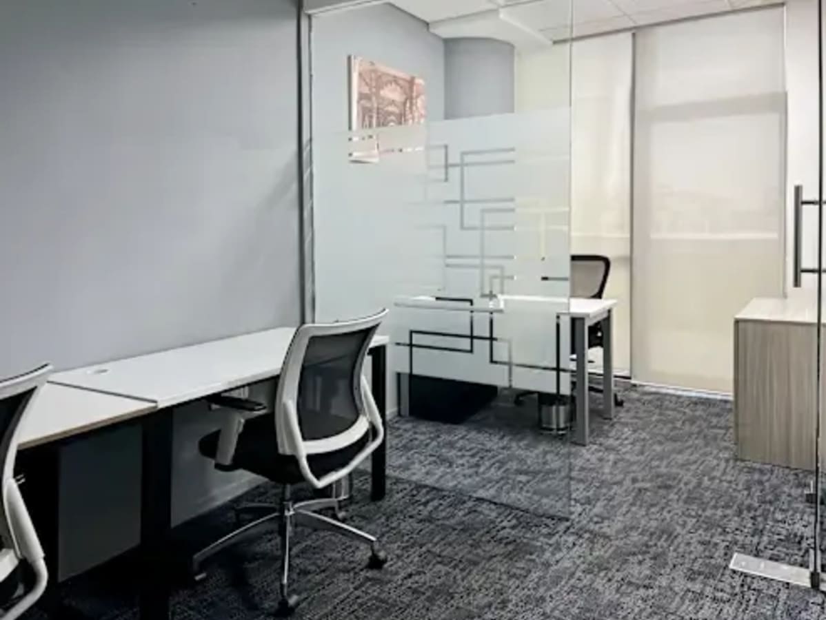 Modern coworking space in Sector 49 with sleek desks and glass partitions for privacy.