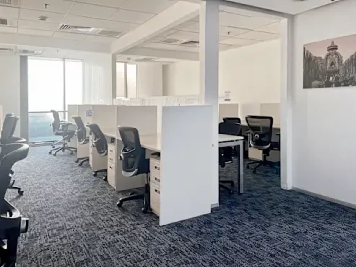 Bright, modern coworking space with ergonomic chairs and ample natural light in Sector 49.