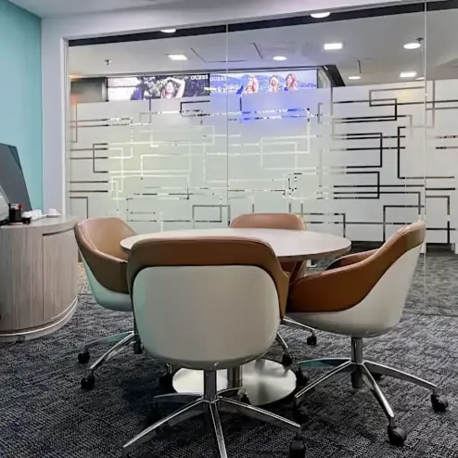Modern coworking area with sleek chairs and a round meeting table, ideal for collaboration.
