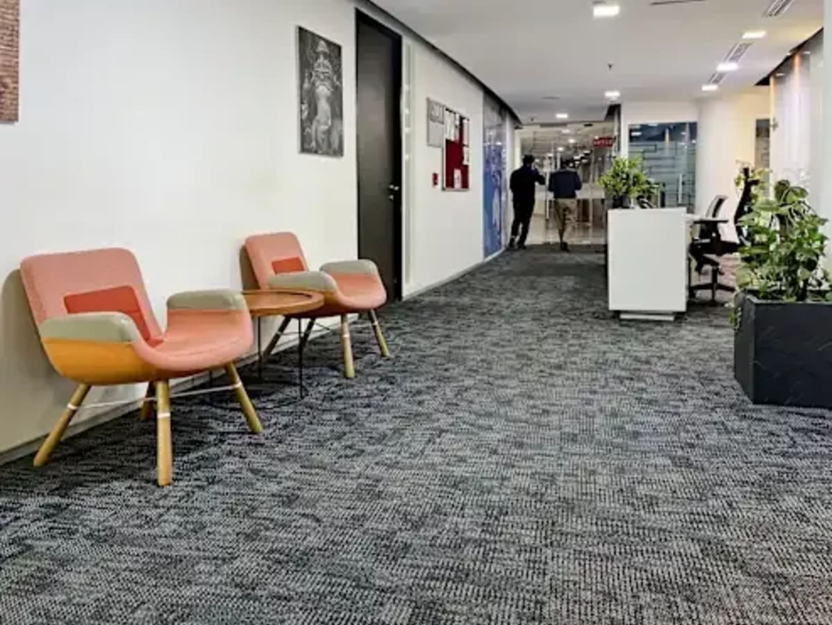Modern coworking space in Sector 49 features stylish seating, natural light, and green accents.