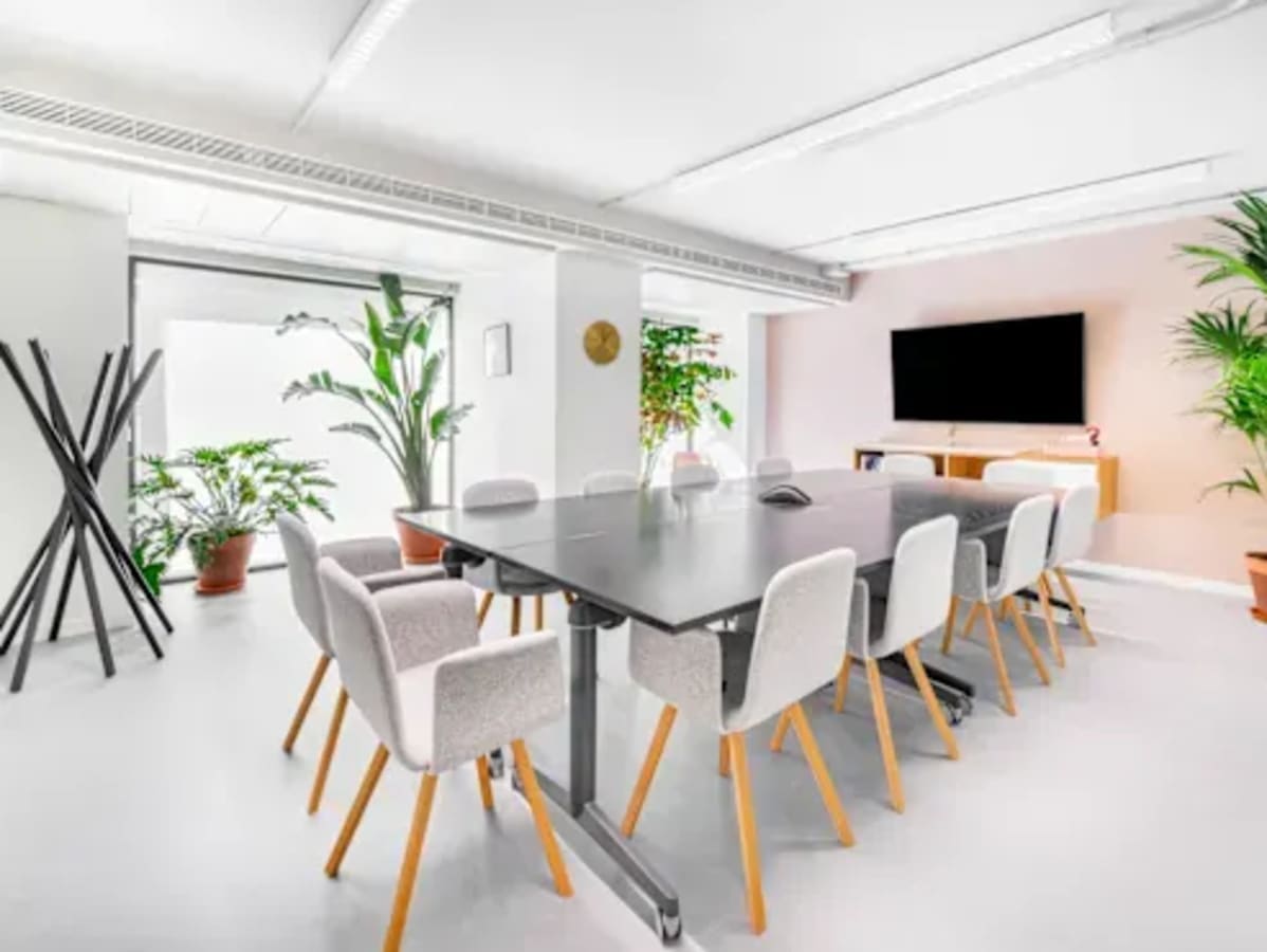 Bright and modern coworking space with a sleek conference table and abundant natural light.