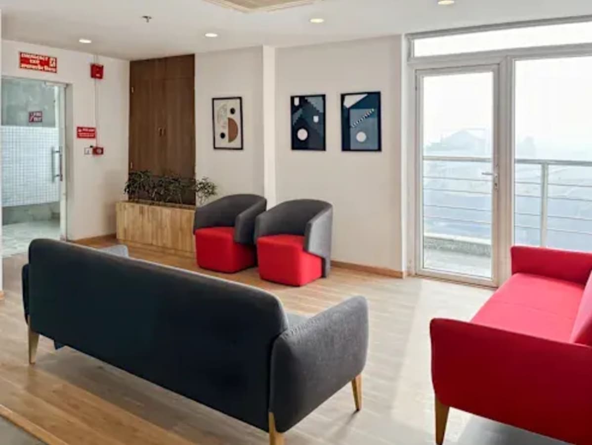 Bright coworking lounge with modern seating, natural light, and artistic decor in Haryana.